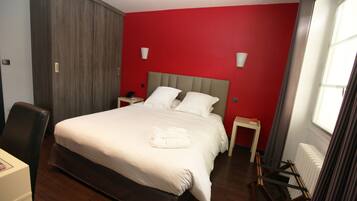 Una habitación de hotel con una cama grande, un escritorio y una silla.