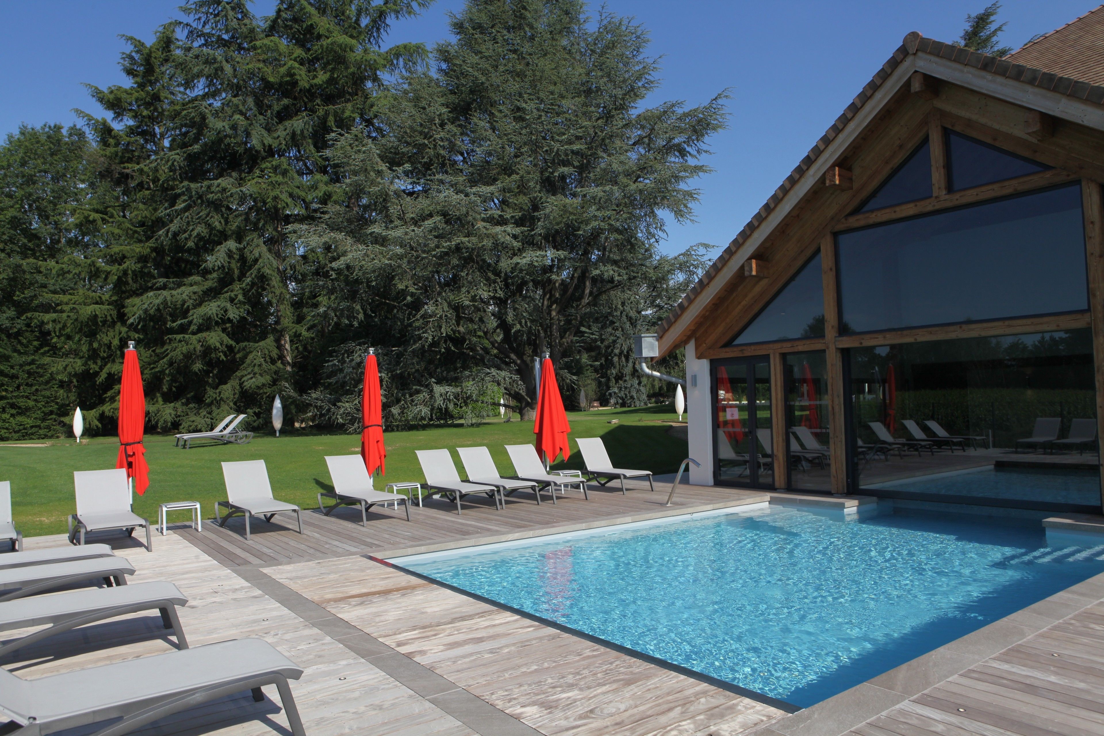 Een binnenzwembad, een buitenzwembad en parasols bij het zwembad