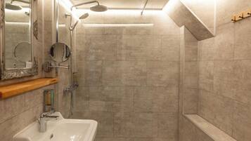 A modern bathroom with a shower, a sink, and a vanity.