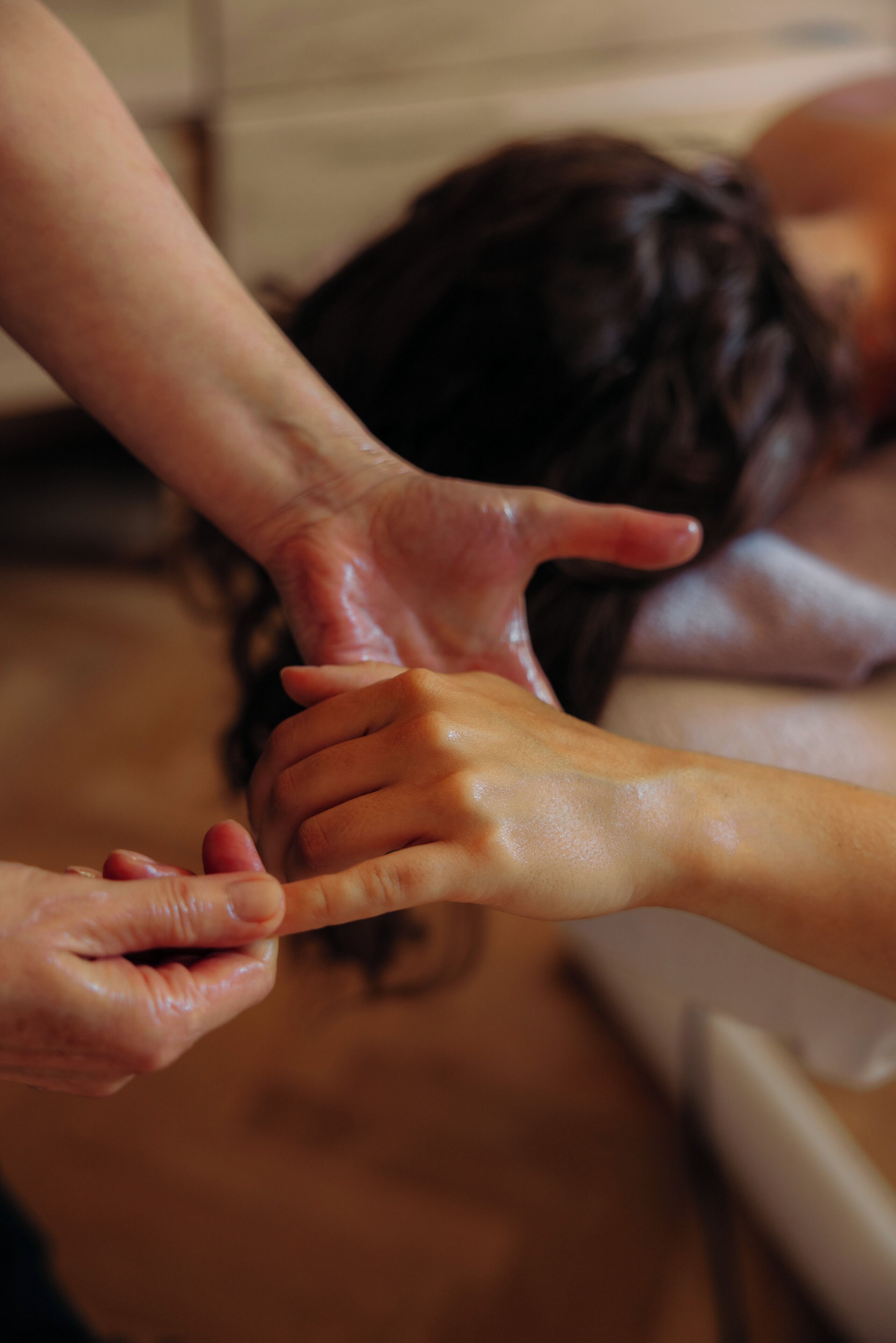 A close-up of hands performing a massage on a person's back.
