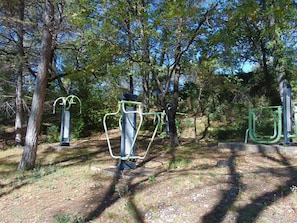 Equipos de ejercicio al aire libre en un parque arbolado.