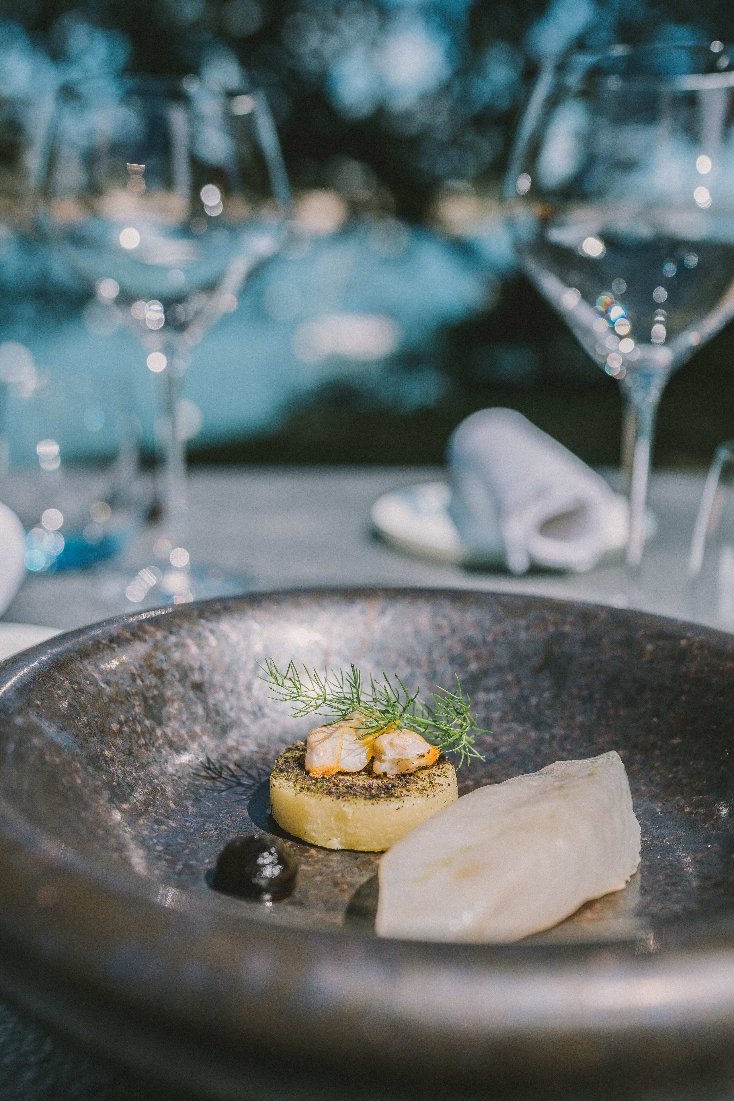 A dining table with a plate of food, a glass of water, and a napkin.
