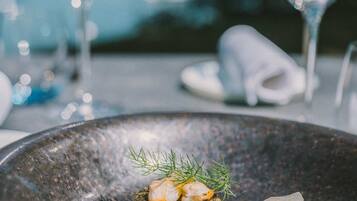 A dining table with a plate of food, a glass of water, and a napkin.