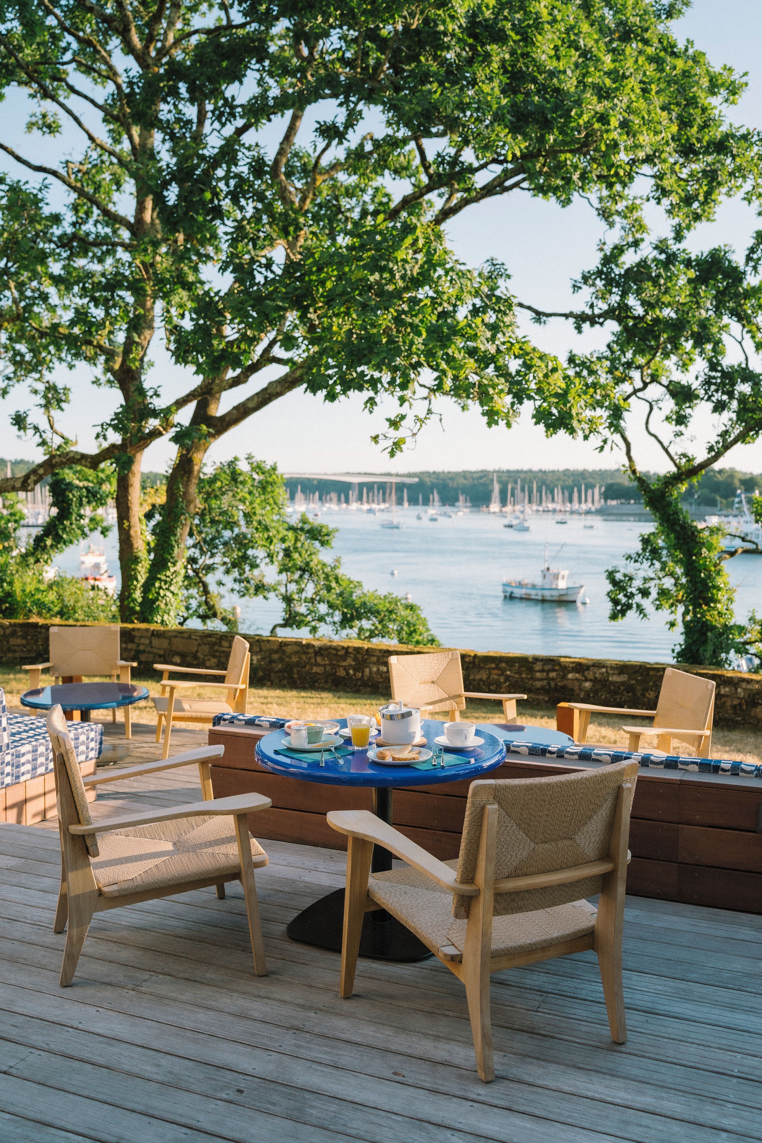 An outdoor seating area with wooden furniture and a view of the water.