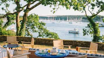 An outdoor seating area with wooden furniture and a view of the water.