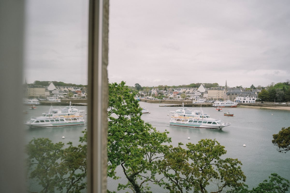 A harbor with multiple boats, buildings, and trees.