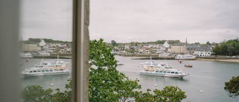 A harbor with multiple boats, buildings, and trees.
