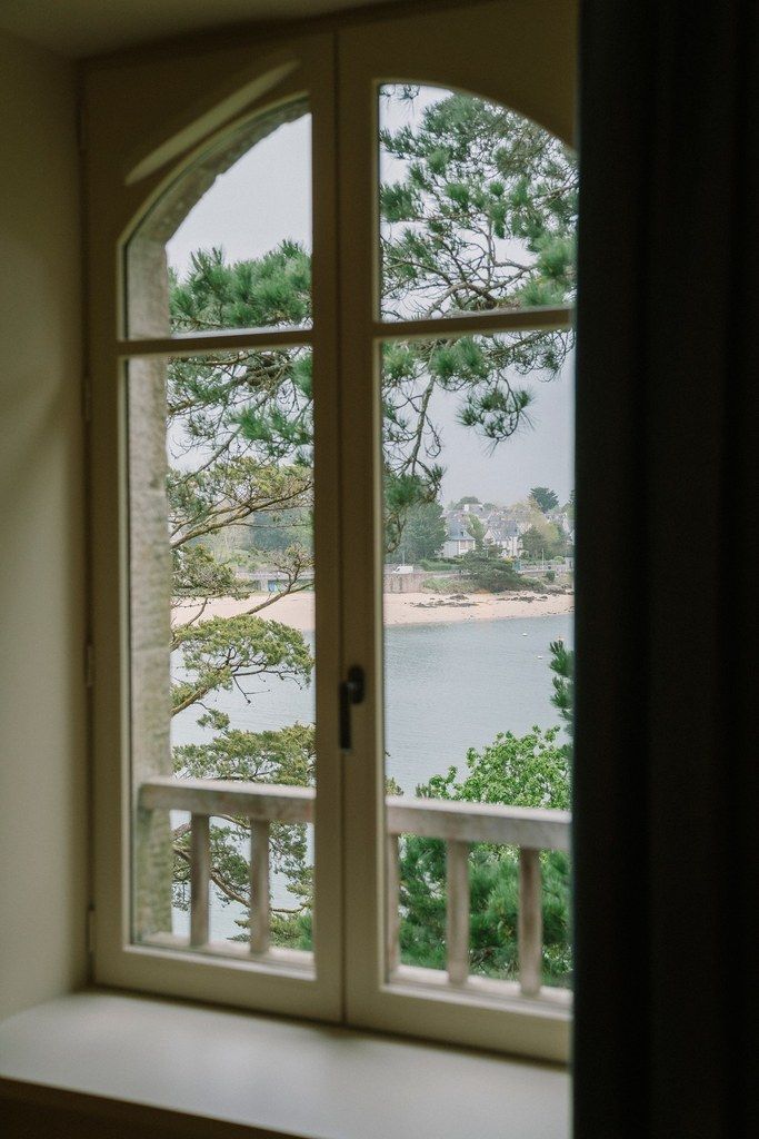 A window with a view of a beach and trees.