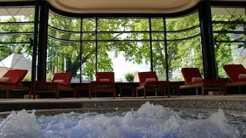 Relax by the bubbling pool surrounded by lush green views and comfortable lounge chairs.