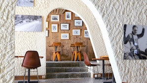 A restaurant with a stone staircase, wooden tables, and chairs.