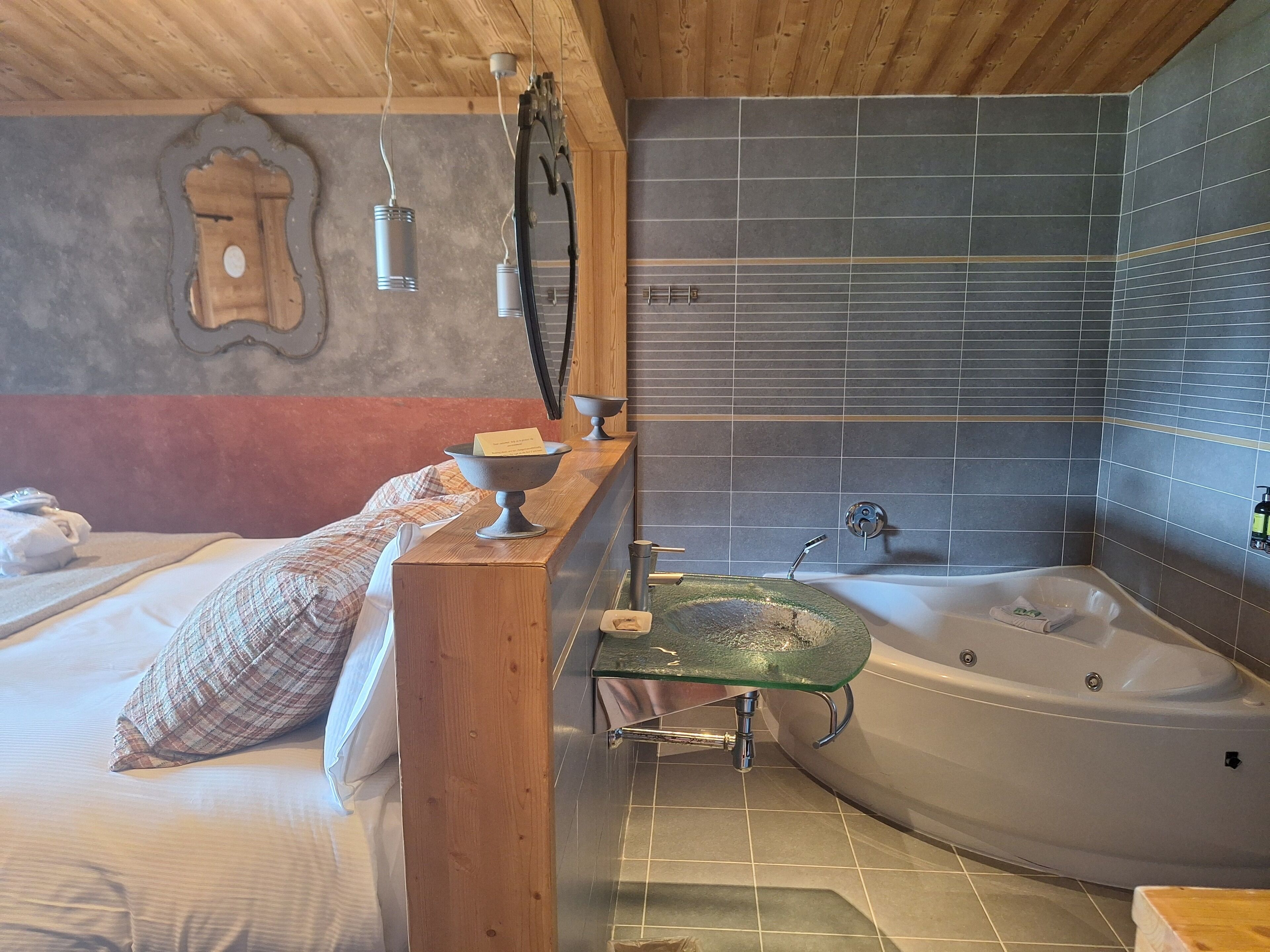 A modern bathroom with a large bathtub, a wooden vanity, and a mirror.