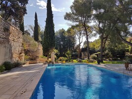 Una piscina al aire libre de temporada, sillones reclinables de piscina