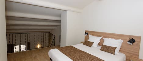 Un dormitorio con una cama grande, cabecera de madera y vistas a un balcón.