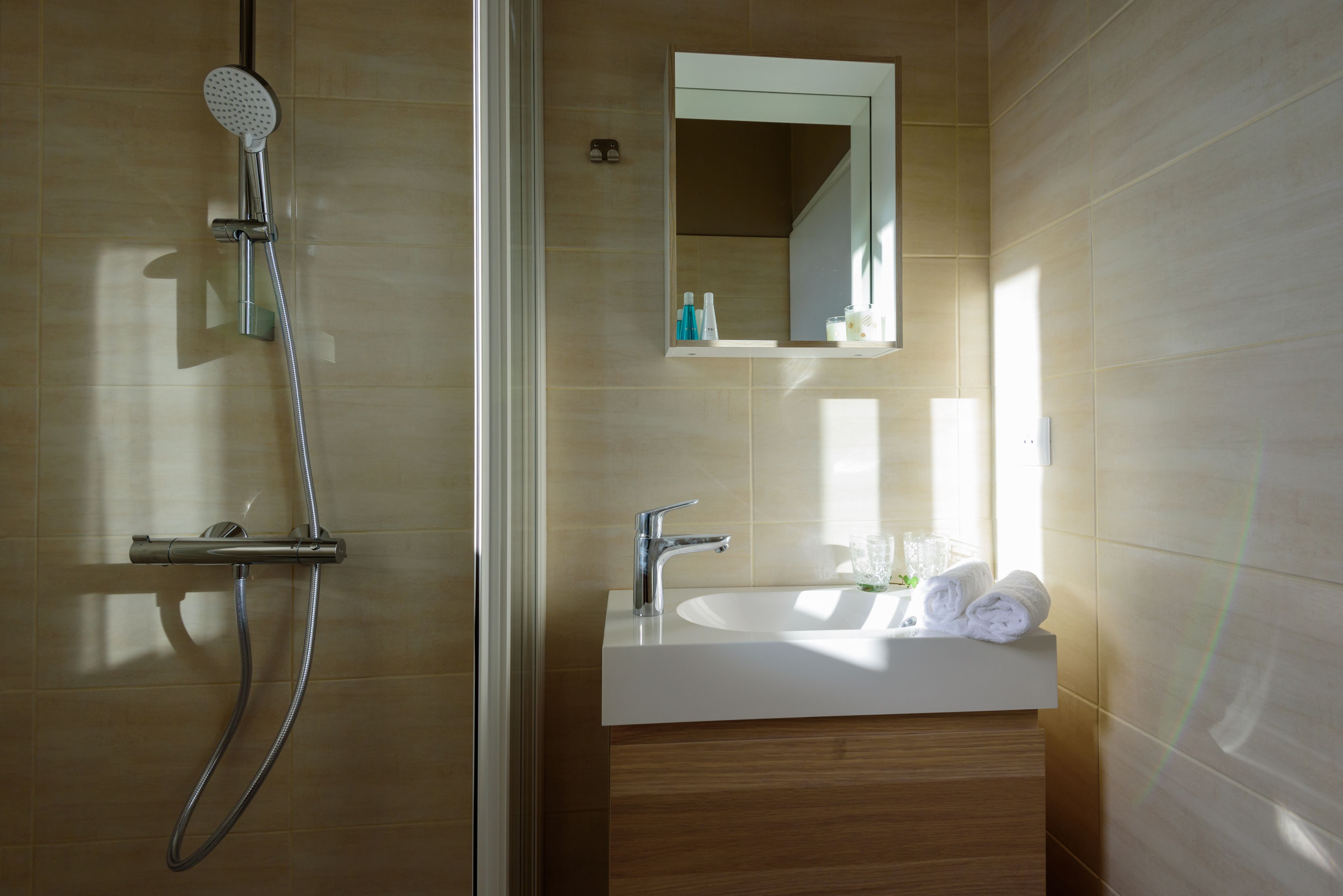 A modern bathroom with a shower, sink, and mirror.