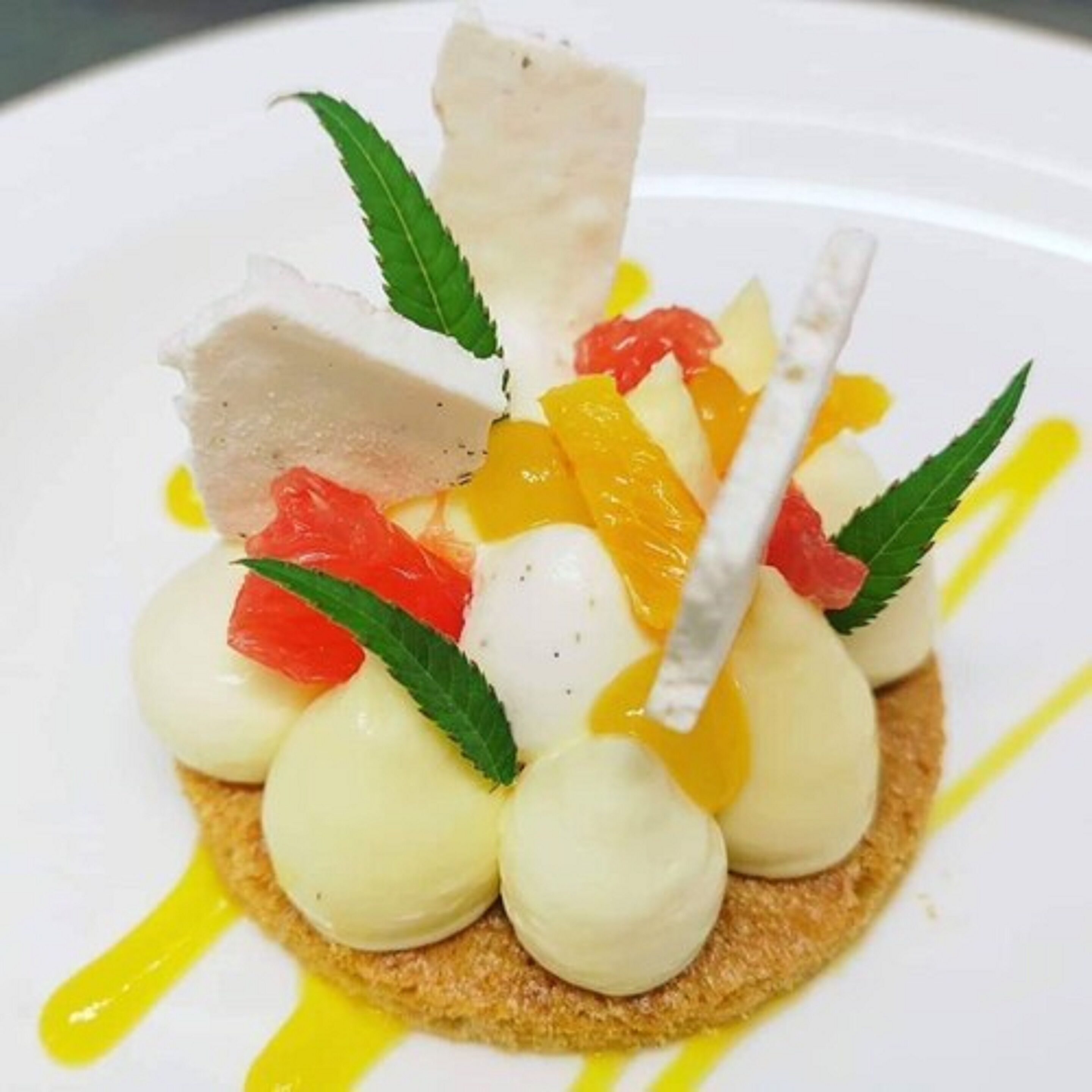 A dessert with fruit and cream on a plate.