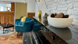 Een modern interieur met een witte schaal op een console tafel, een blauwe bank en een keuken in de achtergrond.
