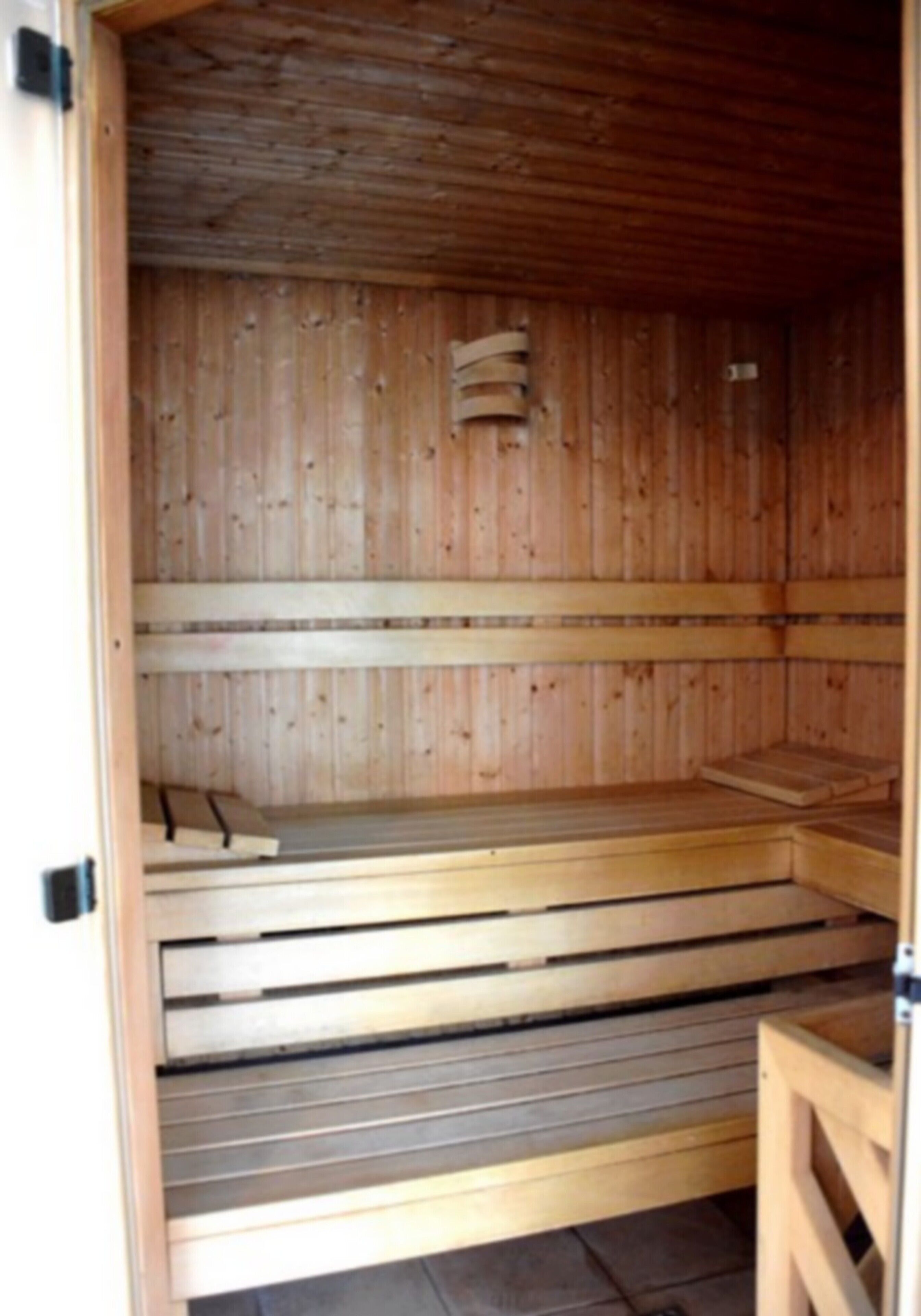 Una sauna amb seients de fusta i un sòl inclinat.