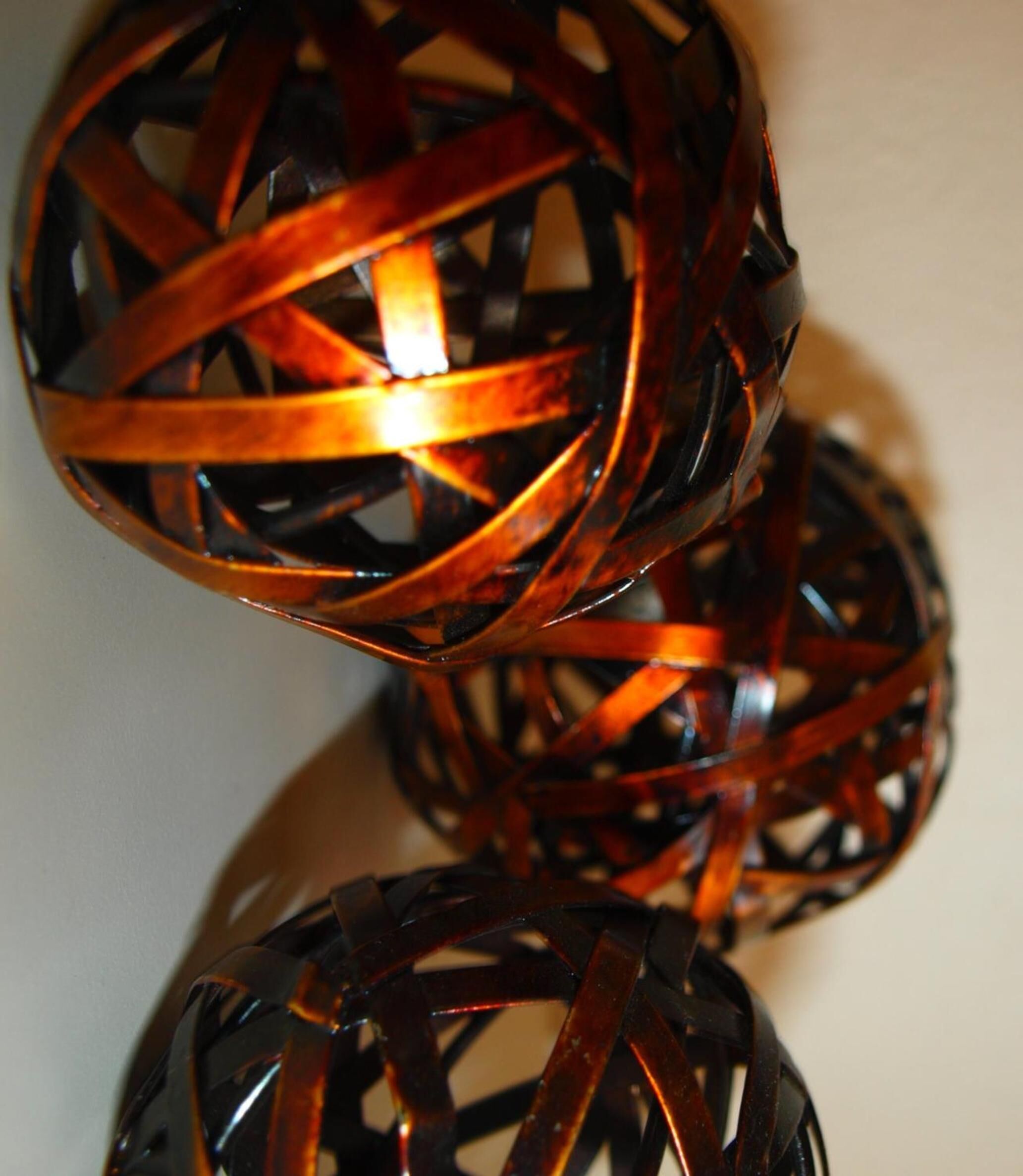A close-up of a woven, spherical object with a glossy finish.
