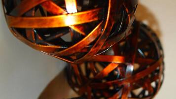 A close-up of a woven, spherical object with a glossy finish.