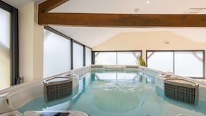 A hot tub with a wooden ceiling and large windows.