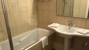 Une salle de bain moderne avec une baignoire, un lavabo et un miroir.