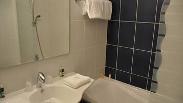 Un baño con lavabo, espejo y bañera.