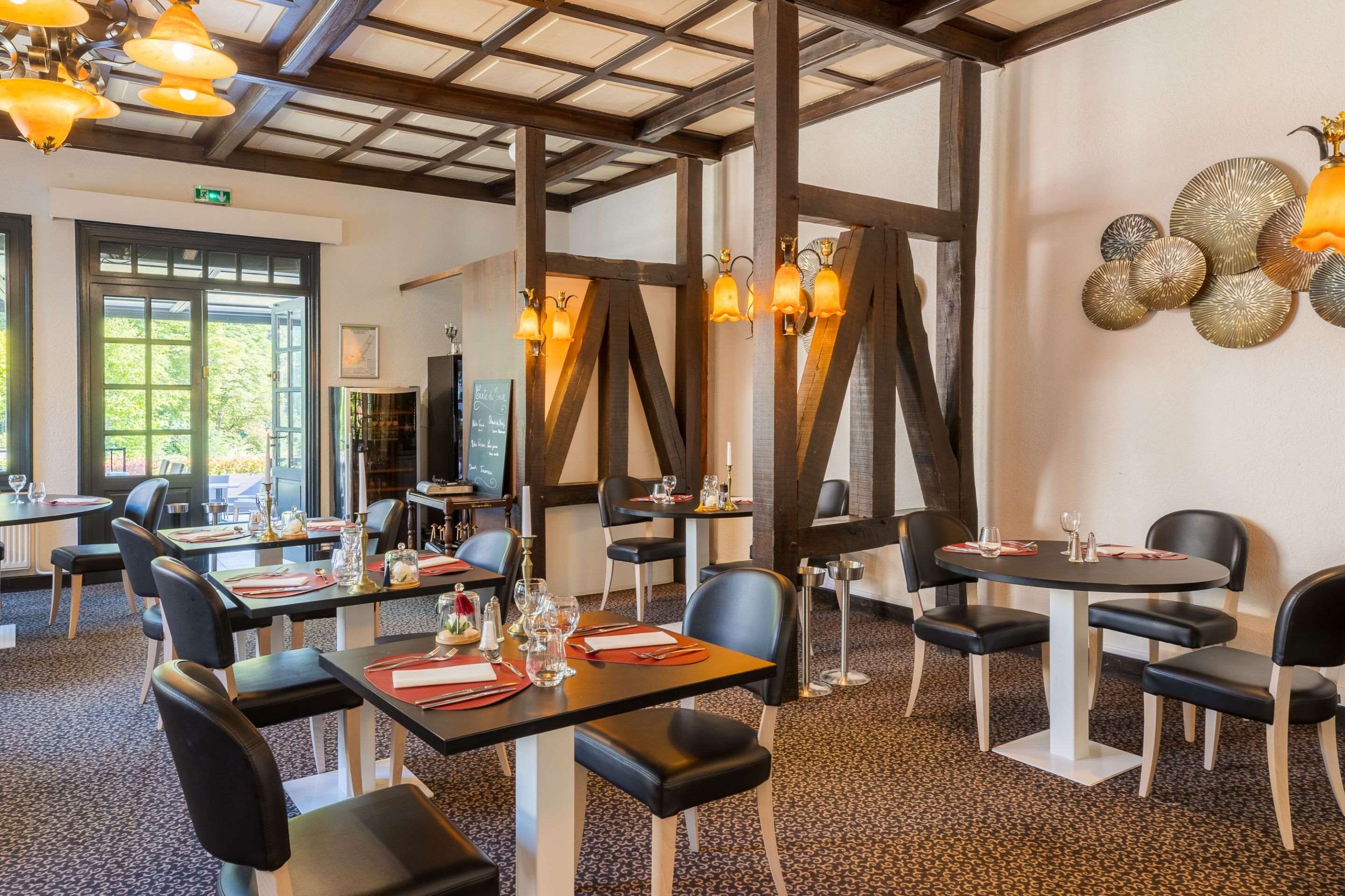 A restaurant with tables and chairs, a chalkboard menu, and decorative wall art.
