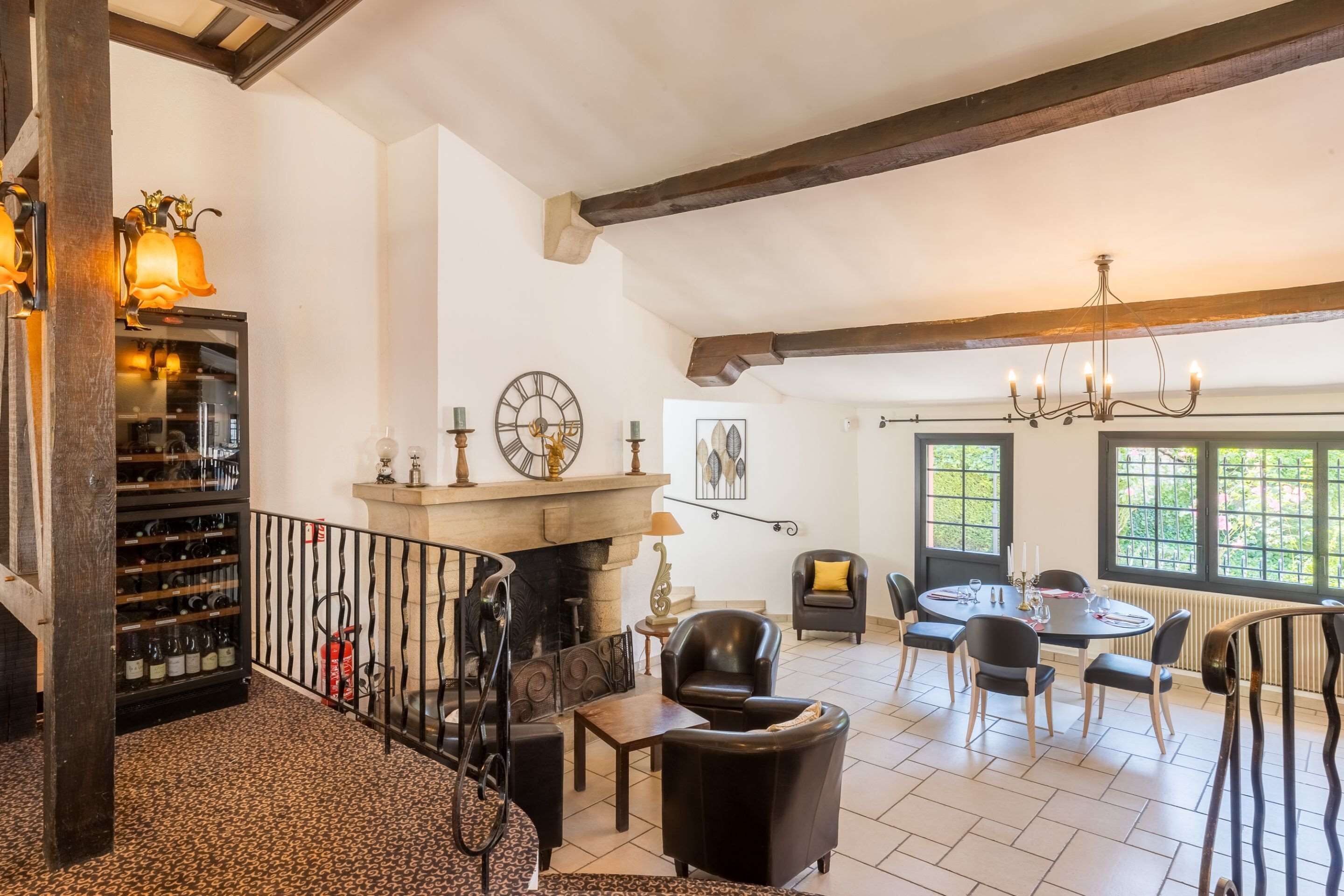 A spacious room with a fireplace, a wine rack, and a dining area with chairs and a table.