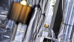 A blurred view of a modern interior with reflective surfaces and a lamp. - The Originals City, Hôtel Napoléon, La Roche-sur-Yon (La Roche-sur-Yon)