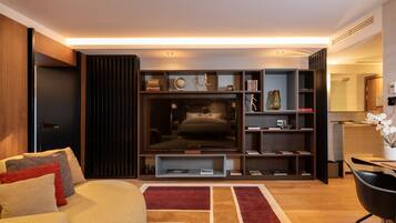 A modern living room with a sofa, a coffee table, a TV, and a bookshelf.