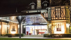 A hotel with a traditional facade, a modern entrance canopy, and a well-lit reception area.