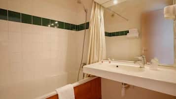 Une salle de bain avec un lavabo blanc, un miroir et un rideau de douche.