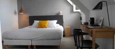 A modern bedroom with a bed, a desk, and a chair.