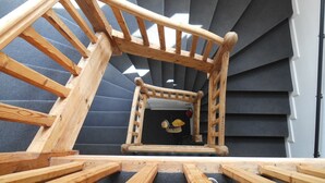 Eine Holztreppe mit Handlauf, die zu einer Zwischenebene führt.