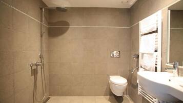 A bathroom with a shower, toilet, and sink.
