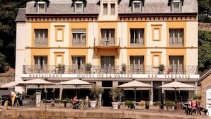 A multi-story hotel with a bar terrace, outdoor seating, and a bike rack. - Hotel de la Vallee (Dinard)