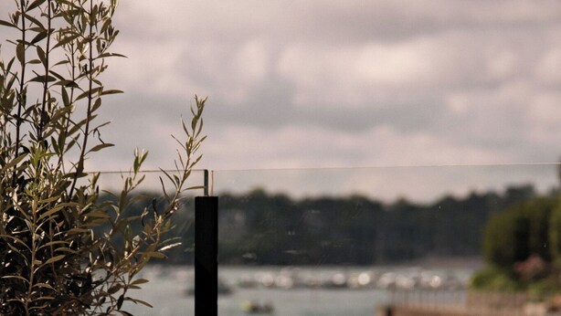 A table with three drinks and a potted plant by a waterfront view. - Hotel de la Vallee (Dinard)