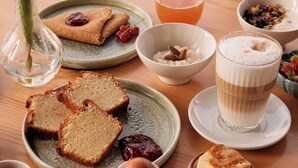 A breakfast setting with bread, a glass of juice, and various small dishes of food. - Hotel de la Vallee (Dinard)
