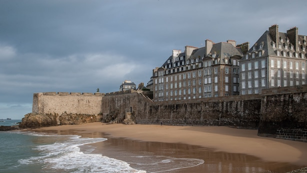 Une fortification côtière dotée d’une plage de sable et d’un grand bâtiment comportant de nombreuses fenêtres.