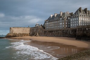 Une fortification côtière dotée d’une plage de sable et d’un grand bâtiment comportant de nombreuses fenêtres.