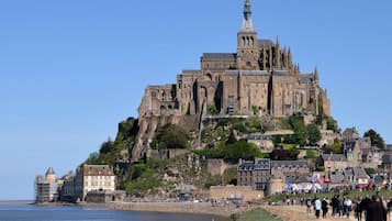 A historic cathedral with a prominent spire, situated on a hill overlooking a coastal town.