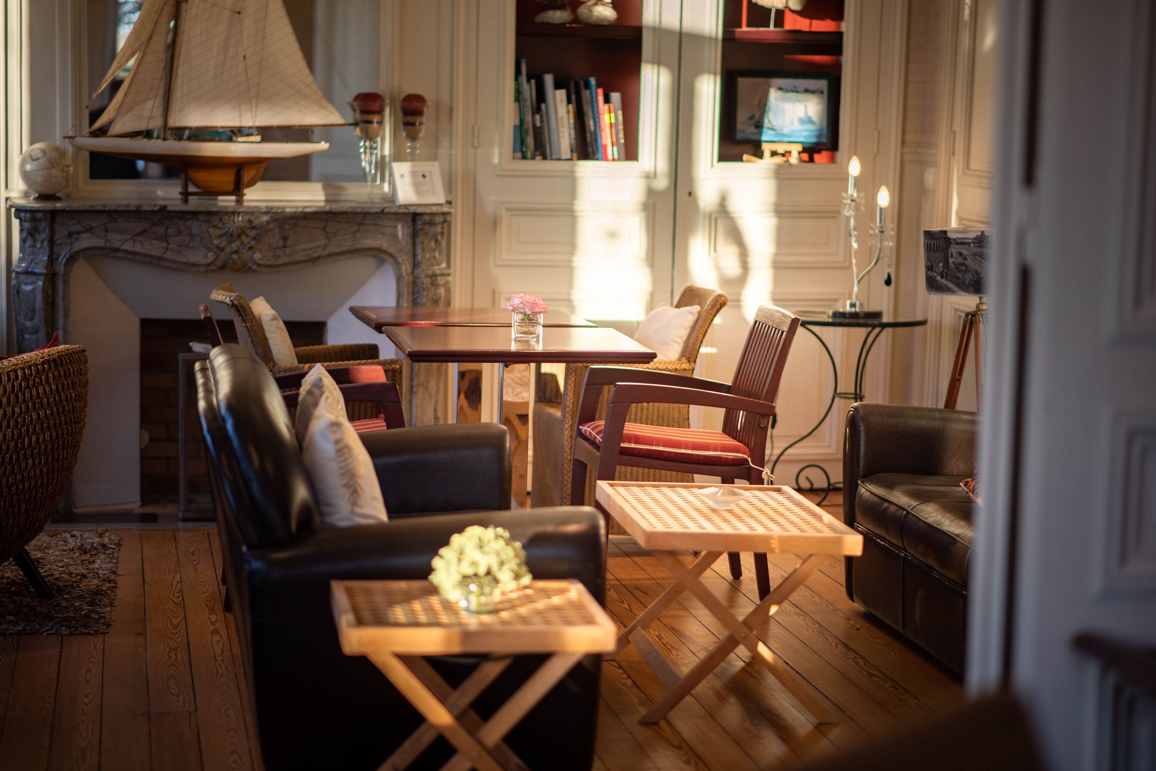 Una sala de estar acogedora con chimenea, sofás de cuero, una mesa de comedor y una estantería.