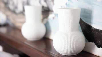 Twee witte vazen op een houten ondergrond.