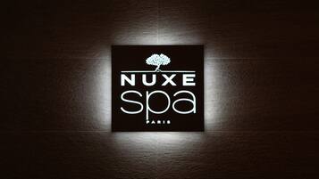 Logo de NUXE SPA en París, con un árbol estilizado sobre el texto.