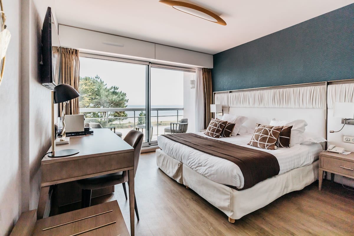 Ein modernes Hotelzimmer mit einem großen Bett, einem Schreibtisch und einem Stuhl.