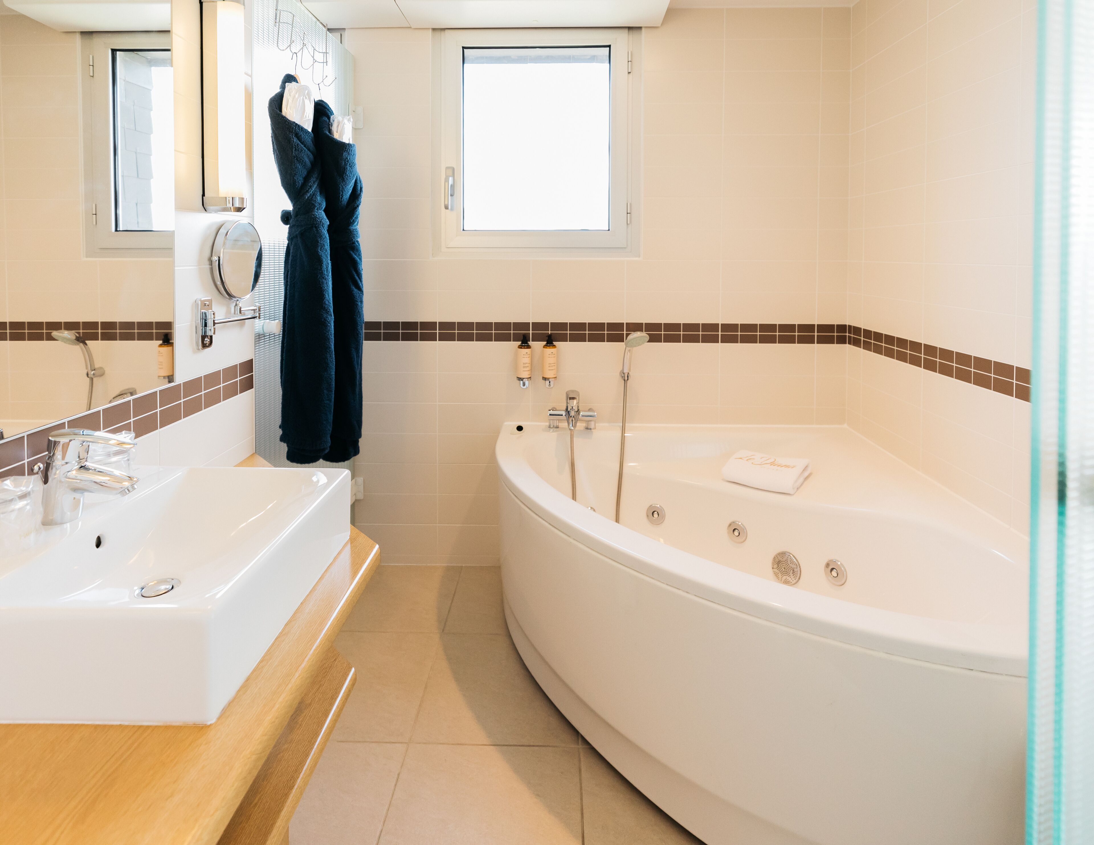 A modern bathroom with a large bathtub, a separate shower area, and a vanity with a sink.