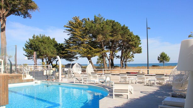 A pool area with lounge chairs and a view of the beach. - Le Diana Hotel and Spa (Carnac)