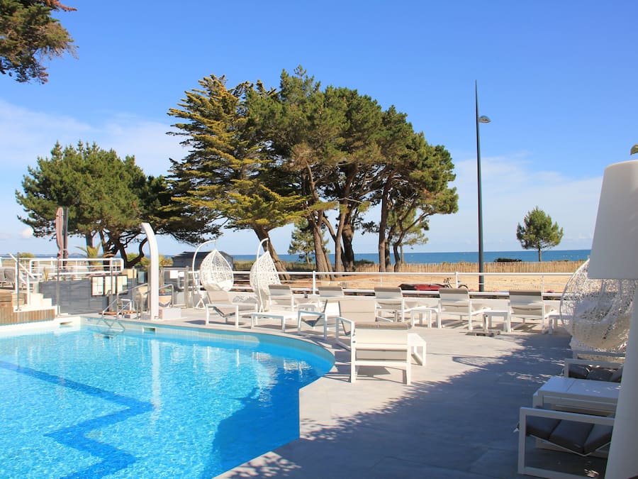 Een buitenzwembad, parasols voor strand/zwembad