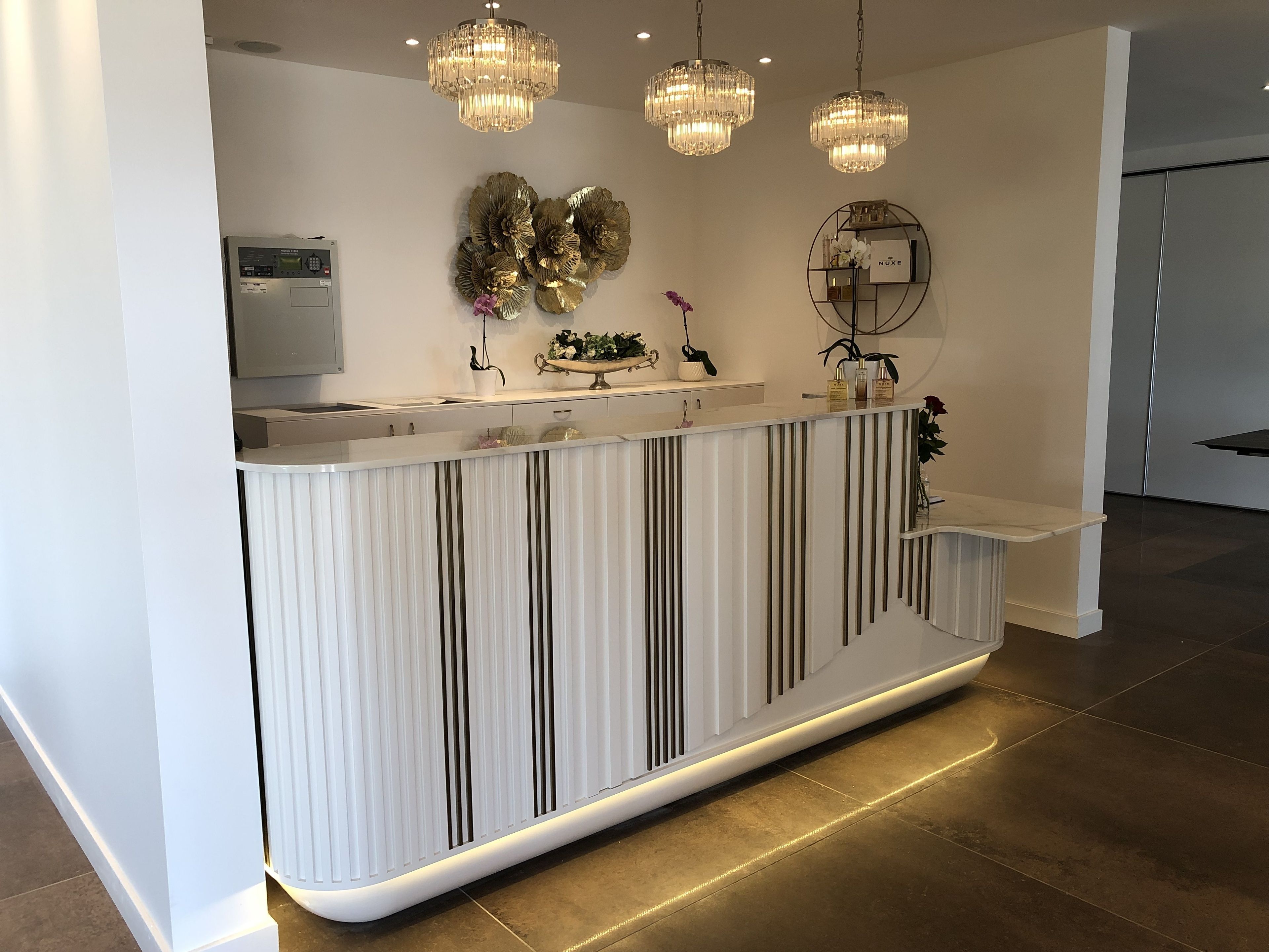 Una cocina moderna con una isla central, luces colgantes y decoración en la pared.