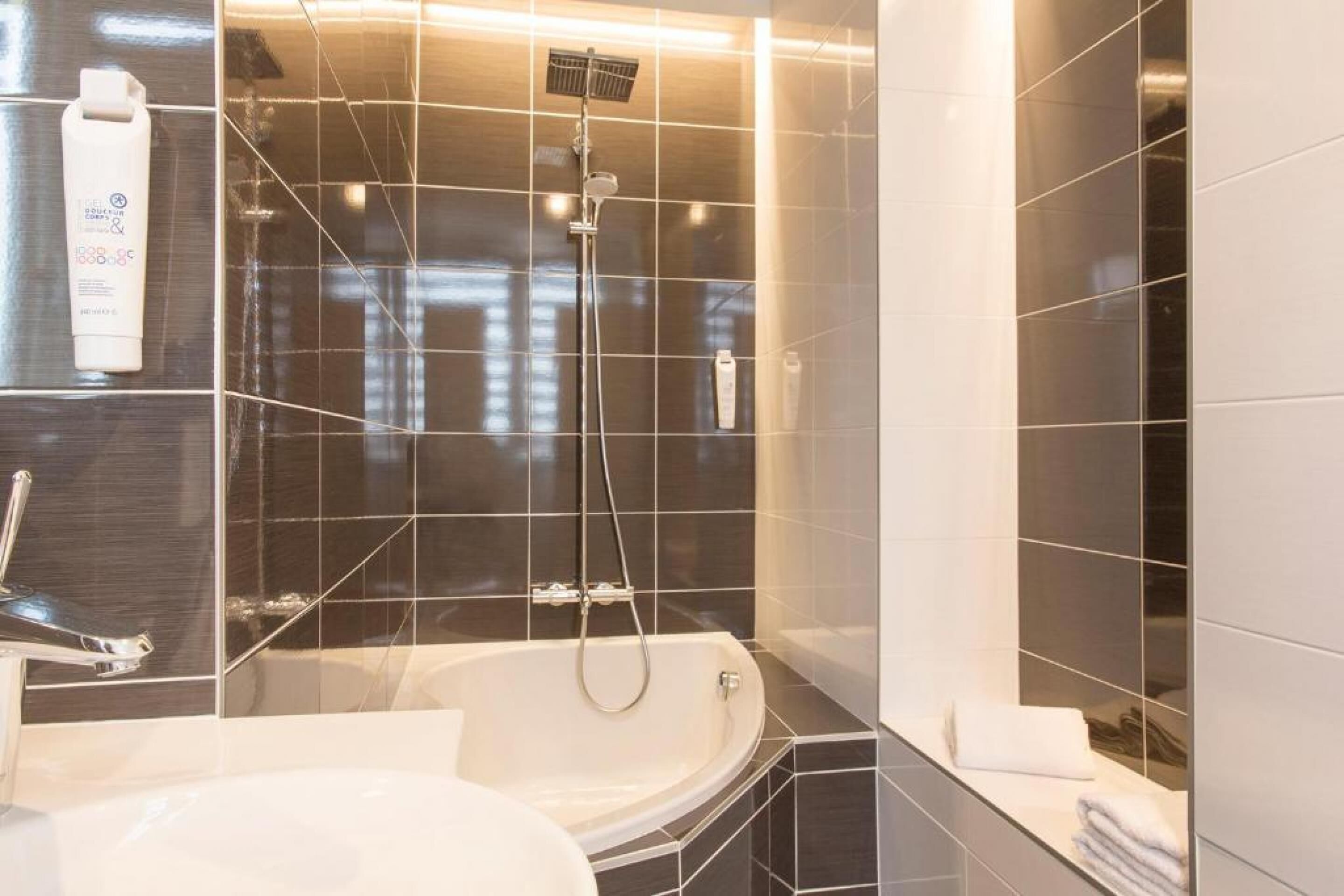 Un baño moderno con bañera, lavamanos y ducha.